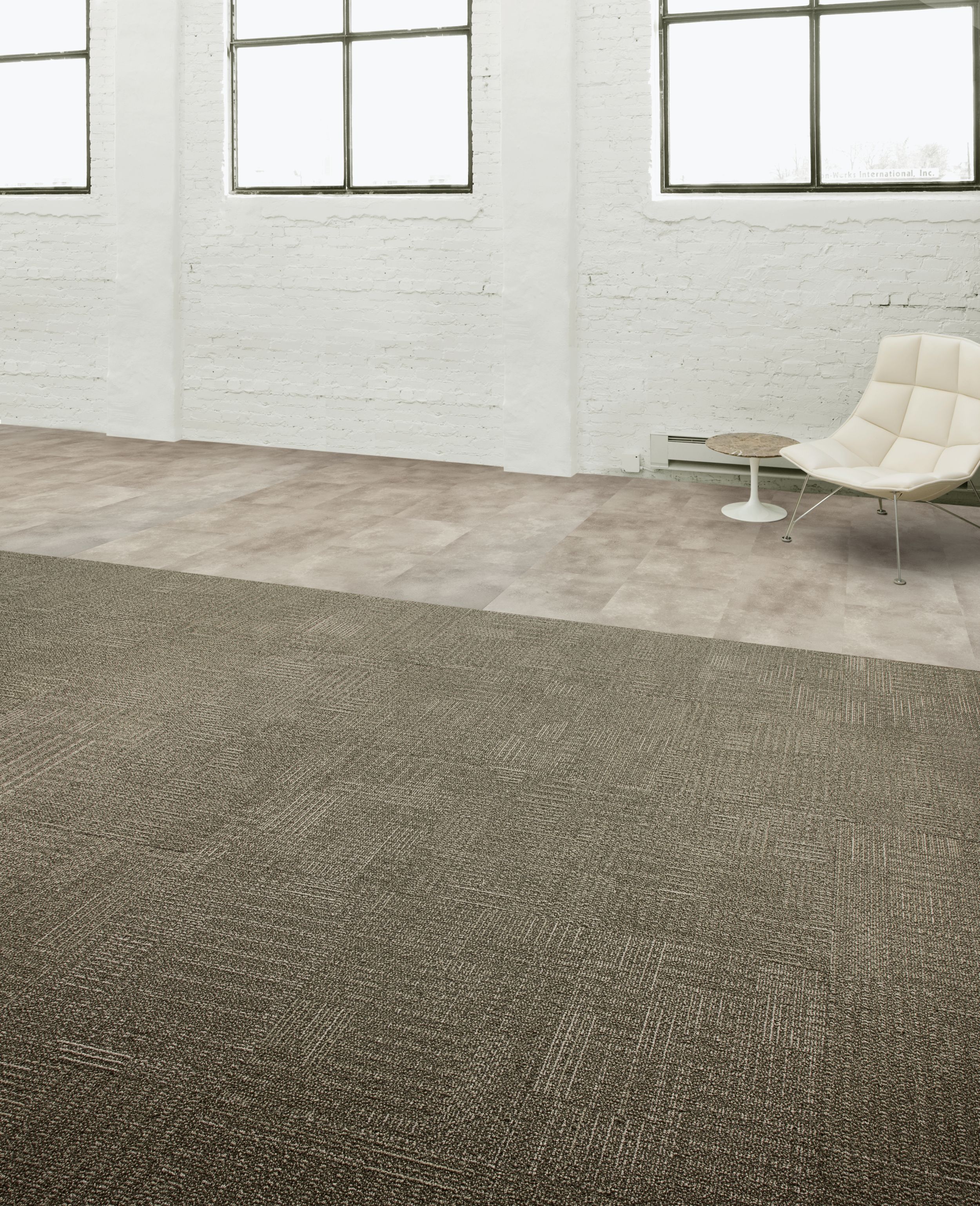 Interface CT101 carpet tile and Textured Stones LVT in open area with concrete walls and chair imagen número 5